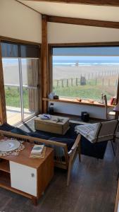 Arenaguas Beach Front House في ماتانزاس: غرفة معيشة مع نافذة كبيرة وإطلالة على المحيط