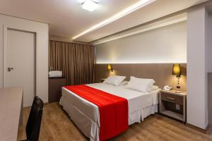 1 dormitorio con 1 cama grande con manta roja en Hotel Farol da Ilha, en Florianópolis