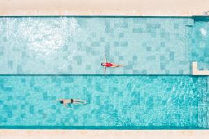 two people swimming in a large swimming pool at Live Aqua Beach Resort Punta Cana - All Inclusive - Adults Only in Punta Cana