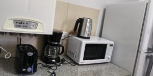 een keuken met een magnetron en een koffiezetapparaat bij Pardelas patagonia in Puerto Madryn