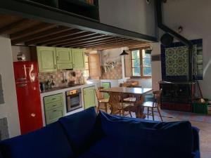 a kitchen with green cabinets and a table with chairs at Loft in Chianti in medieval watermill in Gaiole in Chianti
