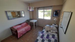 Habitación pequeña con cama y espejo. en Alquilo departamento (termporario) para 6 personas en pleno centro en Necochea