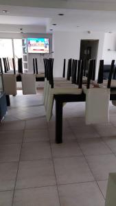 Zimmer mit Stühlen, einem Tisch und einem TV in der Unterkunft Miras Del Mar in Puerto Madryn