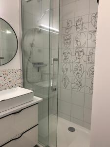 W łazience znajduje się prysznic ze szklanymi drzwiami. w obiekcie Champagne! Appartement spacieux Reims centre w mieście Reims