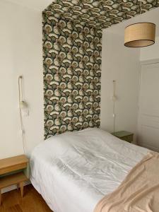 a bedroom with a white bed with a floral wall at Champagne! Appartement spacieux Reims centre in Reims
