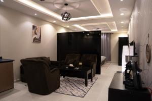 sala de estar con sofá, sillas y mesa en Fans Hotel Suites en Abha