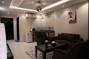 艾卜哈的住宿－Fans Hotel Suites，客厅配有沙发和桌子