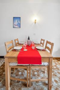 a wooden table with four chairs and a red table cloth at Flat close to Zermatt - Klein Matterhorn view in Randa
