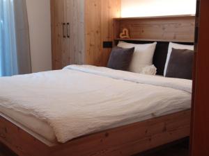 Schlafzimmer mit einem großen Bett mit einem Kopfteil aus Holz in der Unterkunft Lampenhof in Bruneck