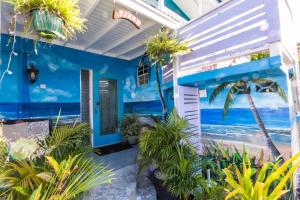 a blue house with a mural of the beach at Shama's Guest House in Christ Church