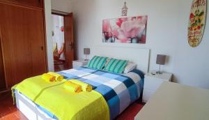 - une chambre avec un lit jaune et bleu dans l'établissement Luz Beach Ocean Front Apartment, à Luz