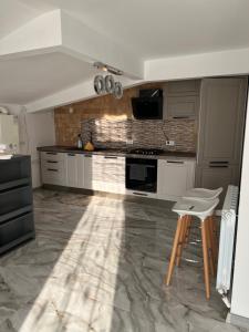 a kitchen with white cabinets and a marble floor at Sarah relax2 in Drobeta-Turnu Severin