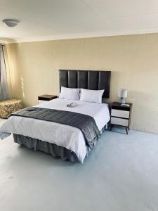 a bedroom with a large bed and a chair at One Home in Pretoria