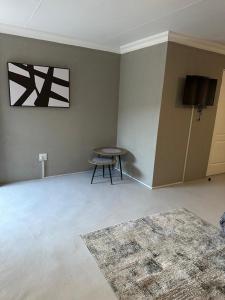 an empty living room with a table and a tv at One Home in Pretoria