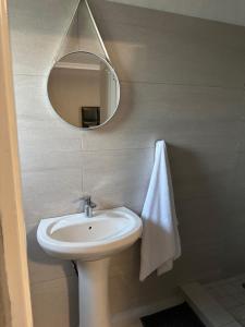 a bathroom with a white sink and a mirror at One Home in Pretoria