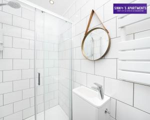 a white bathroom with a sink and a mirror at 1 Bed Central London Apartment in London