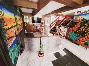 Habitación con pinturas en las paredes y escalera. en Divino Niño Hotel en Leticia