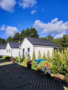 a house with a garden in front of it at Domki u Pana Zielonki in Rusinowo
