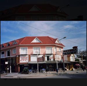 un edificio con techo rojo en una esquina de la calle en Pinamar 497 en Pinamar