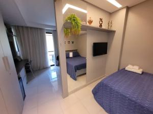 1 dormitorio con 2 camas, TV y espejo en Praia dos Carneiros Flat 120-CM Eco Resort - ao lado da igrejinha, en Tamandaré