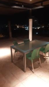 a table with four green chairs around it at night at OBLIGADO ESTUDIO SAN PEDRO in San Pedro