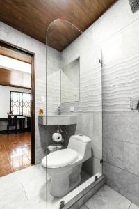 a bathroom with a toilet and a glass shower at Casa Iris - Nature Delight in Puerto Viejo