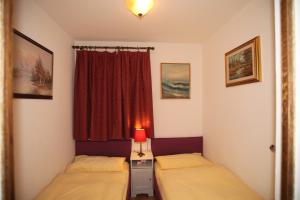 - 2 lits dans une petite chambre avec fenêtre dans l'établissement Fiume Appartamento, à Tegna