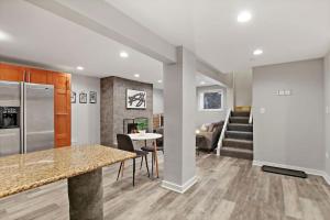 芝加哥的住宿－Chic 1BR Apartment With Modern Comforts - Barry GA，厨房以及带冰箱和桌子的客厅。