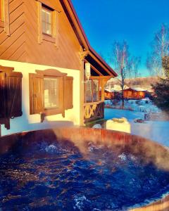 a large pool of water in front of a house at Lesne Domki in Prokowo