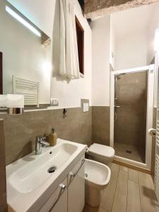 ein weißes Bad mit einem Waschbecken und einem WC in der Unterkunft River Castle Central Verona in Verona