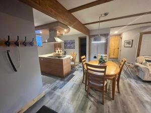 a kitchen and dining room with a table and chairs at Appartement Mont Édouard, Hébergement paisible à la montagne in LʼAnse-Saint-Jean