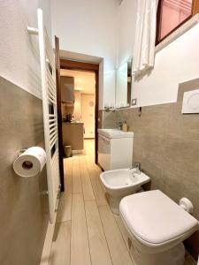 a bathroom with a white toilet and a sink at River Castle Central Verona in Verona
