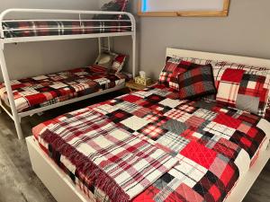 1 Schlafzimmer mit 2 Etagenbetten mit einer Decke in der Unterkunft Hébergement paisible à la montagne in LʼAnse-Saint-Jean