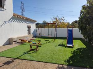 un patio con un parque infantil con un columpio en La Isla de la Vía, en Archidona