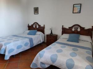 a bedroom with two beds with blue pillows at La Isla de la Vía in Archidona
