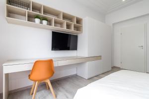 a bedroom with a desk with a tv and a chair at Modern Apartment in the Heart of Bucharest in Bucharest