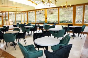 een restaurant met tafels, stoelen en ramen bij Gesundheits- & Wellnessresort Salzerbad in Kleinzell