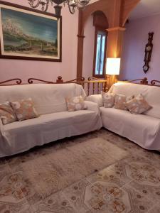 una sala de estar con 2 sofás blancos y una alfombra en LILY - STORIE DEL BOSCO -, en San Felice sul Panaro