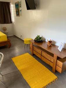 a living room with a table and a yellow rug at Bungalow APETAHI in Faaa