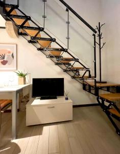 ein Wohnzimmer mit einem TV und einer Treppe in der Unterkunft River Castle Central Verona in Verona