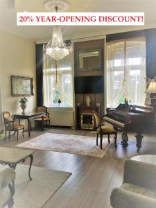 een woonkamer met een piano en een kroonluchter bij Logod Panorama Apartman in Boedapest