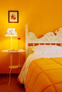 a yellow bedroom with a bed and a table with a lamp at Le Stanze dei Nonni in Avellino