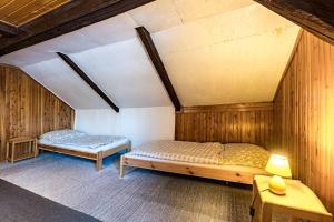 two beds in a room with wooden walls at Chata Koza in Bublava