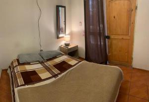 a bedroom with a bed and a table with a lamp at Casa R in Calama