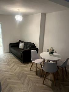 a living room with a couch and a table and chairs at Modern welsh cottage in Porth