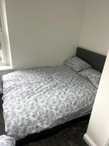 Una cama en una habitación con colcha. en Modern welsh cottage en Porth