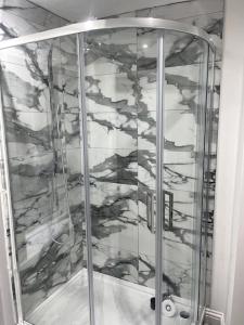 a shower with a glass door in a bathroom at Modern welsh cottage in Porth