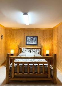 una camera da letto con un grande letto in legno con due lampade di One of a Kind Rustic Log Cabin near Bryce Resort - Large Game Room - Fire Pit - Large Deck - BBQ a Basye