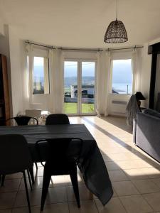 un soggiorno con tavolo e sedie e vista sull'oceano di Grande maison chaleureuse avec vue mer imprenable a Criel-sur-Mer