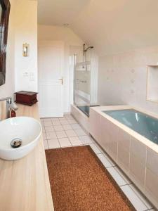 un ampio bagno con vasca e lavandino di Grande maison chaleureuse avec vue mer imprenable a Criel-sur-Mer